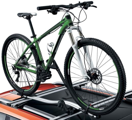 Bike Carrier mounted on car roof holding a green mountain bike